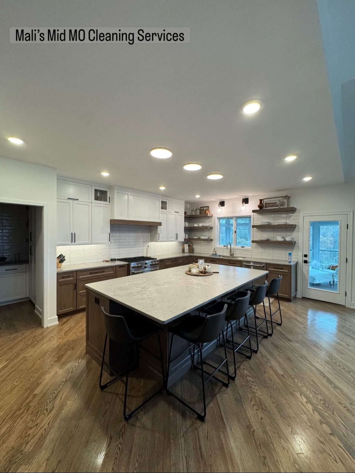 A bright, freshly cleaned kitchen with an island and warm hardwood floors